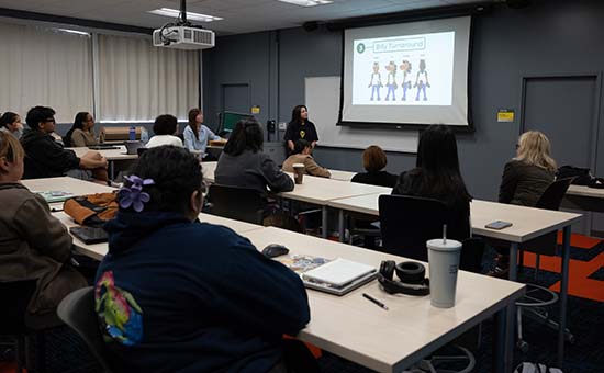 students watch and listen to a presenter in the classroom