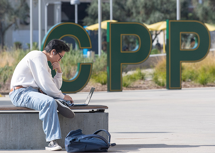 student studying on laptop outdoors