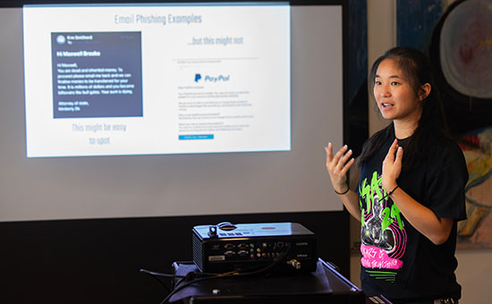 a student presents in front of projected screen