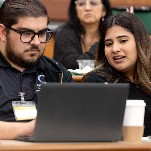 two people looking at a laptop