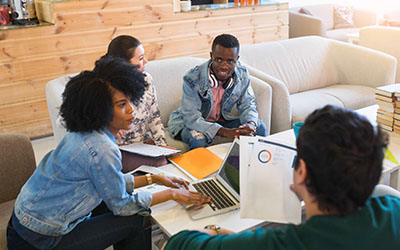 students sitting at a desk using a laptop