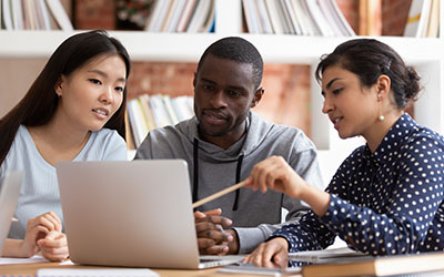 three students working on laptop together