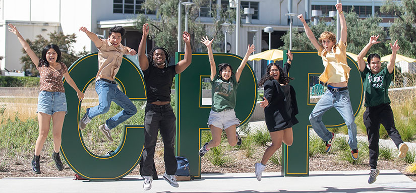 students jumping in front of large CPP letters