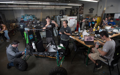 Students working in a lab and assembling a vehicle