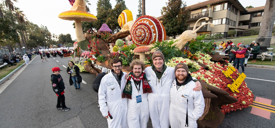 group of students stand in front of CPP float