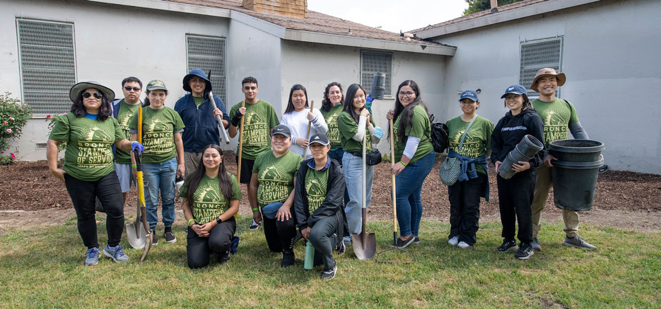 groups of students standing with shovels and rakes