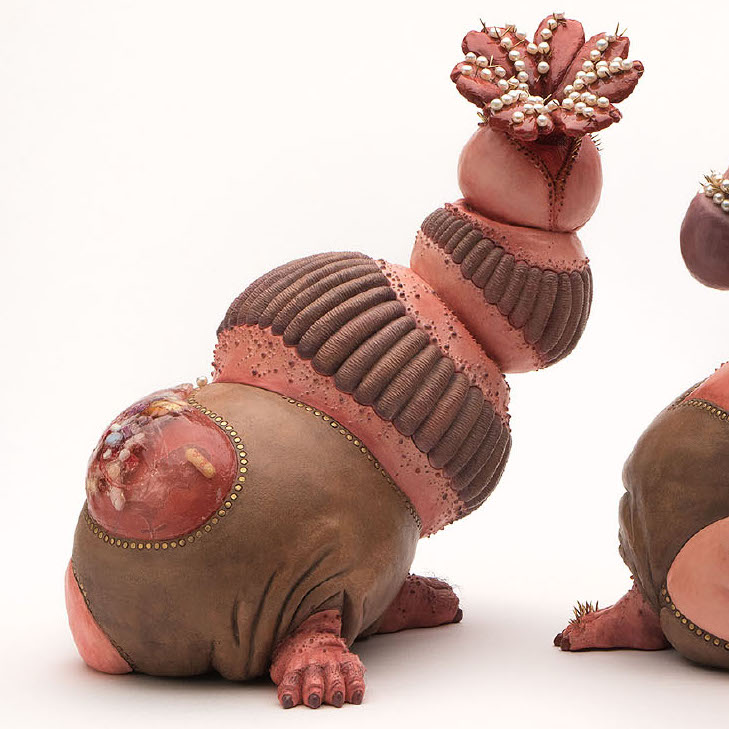 Maria Bruckman, In pari delicto, 2018. Porcelain, acrylic, resin, pins, baroque pearls, fibers 10.5 x 9 x 15" Courtesy of the artist. Two pink colored creatures with brown clothing and hairy feet