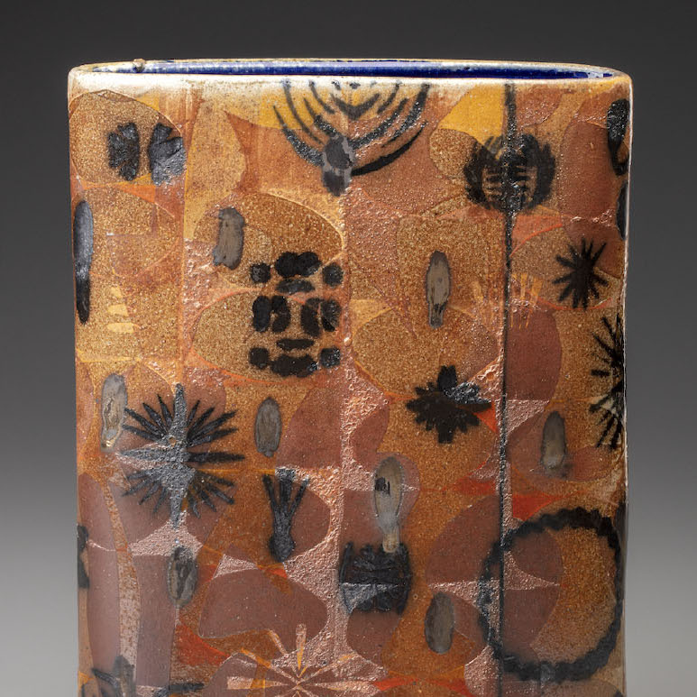 Robbie Heidinger, Massachusetts Medicinals, 2018. Stoneware 14 x 10 x 3.5” Courtesy of the artist. A cylindrical sculpture with various shapes and patterns in orange, black, and light yellow