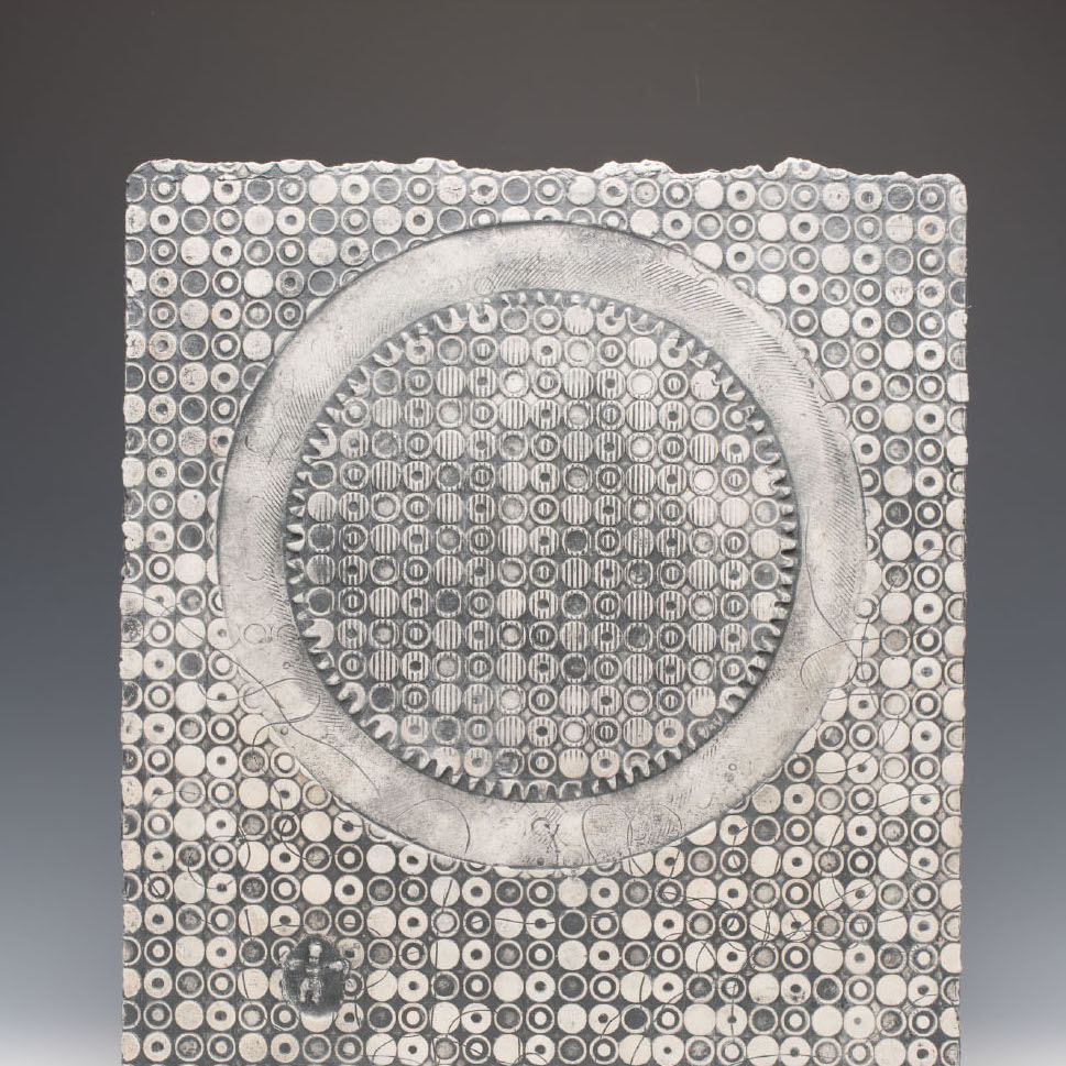 Stephen Horn, Baby Matrix #1, 2019. White stoneware Paperclay, cone 06-fired. 20.5 x 17.5 x .25” Courtesy of the artist. A rectangle shaped sculpture with a large circle and many small circles