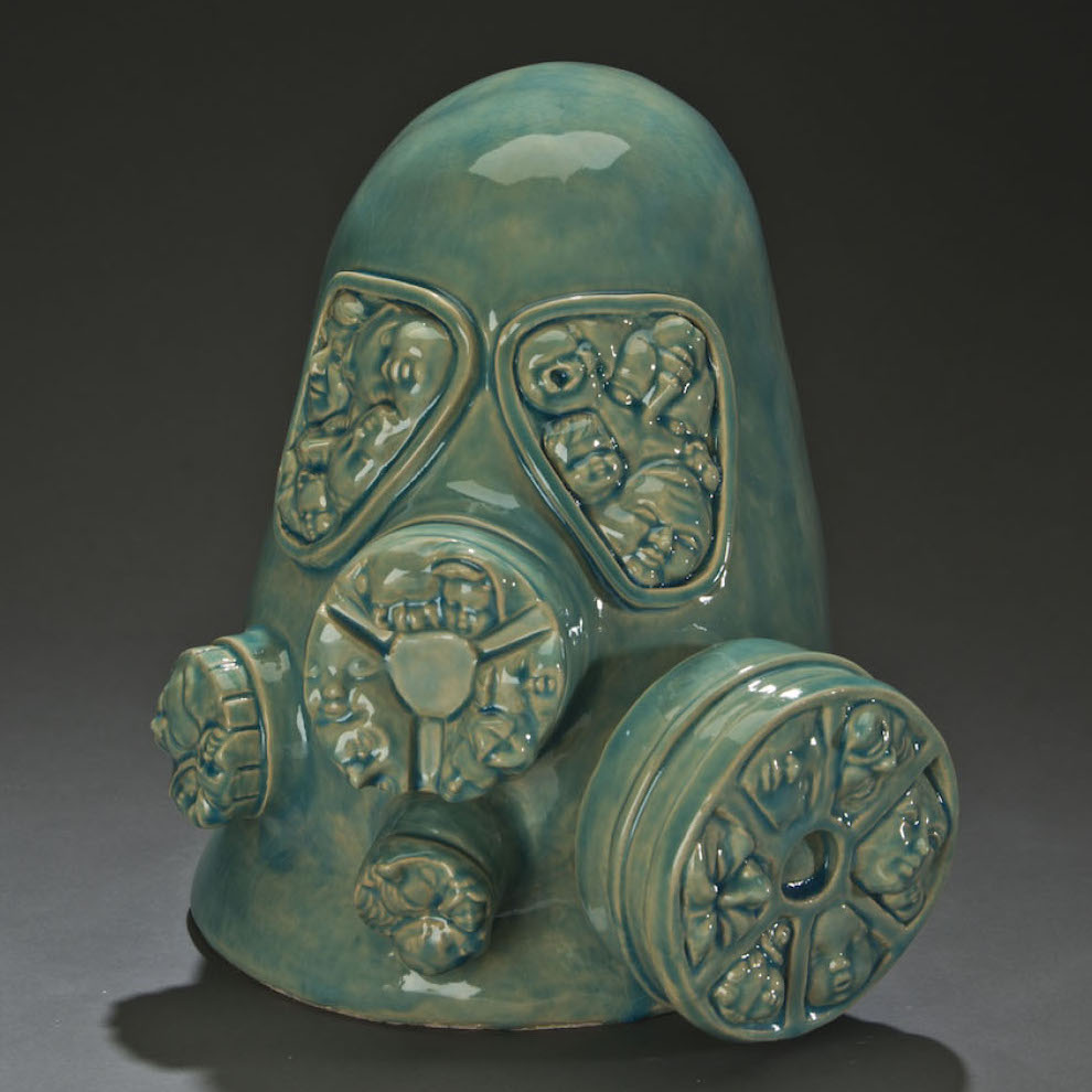 Pancho Jimenez, Gas Mask, 2018. Ceramic. 14 x 13 x 15” Courtesy of the artist. A sculture of a gas mask with depictions of baby heads in the mask openings