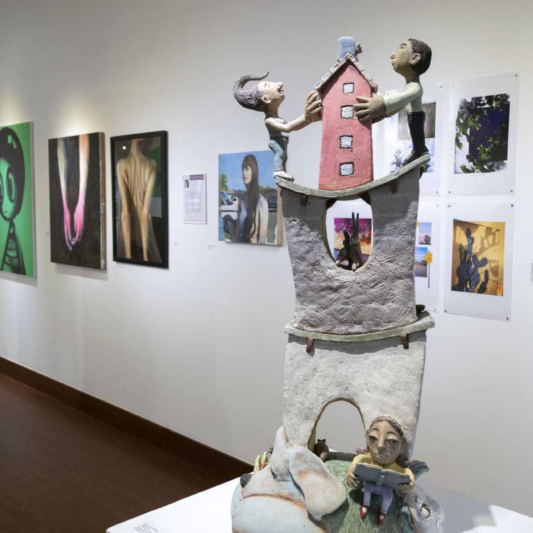 Gina Lawson Egan, Unity, 2018. Ceramic, cone 02-fired, colored slips, stains and glazes. 35 x 17 x 13” Courtesy of the artist. A sculpture of a two people on top of a bridge with animals and water surrounding them