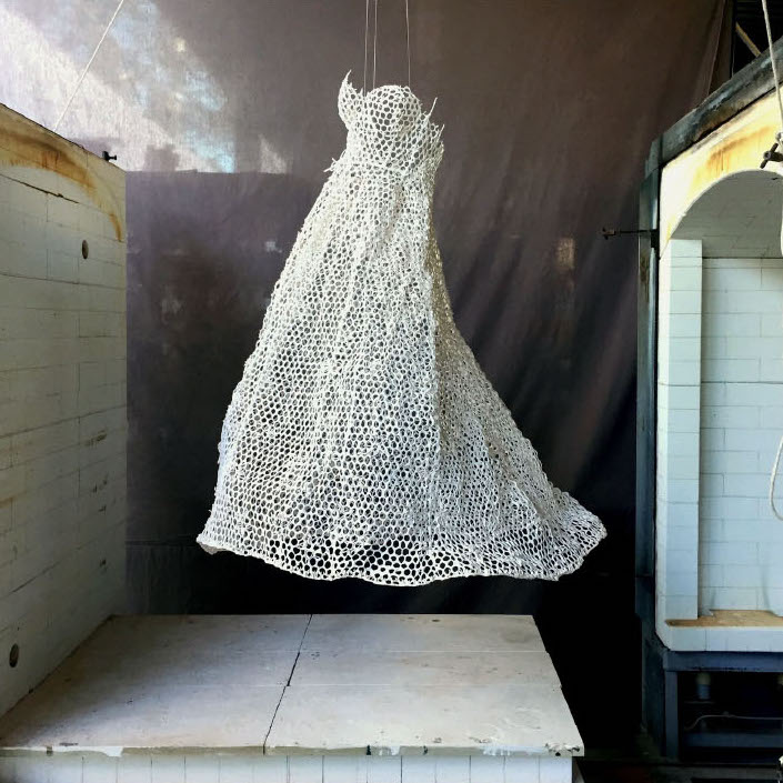 Lily Pon, Dream Dress, 2018. Ceramic hanging sculpture. 52 x 38 x 42” Courtesy of the artist. A hanging sculpture of a white dress with holes that have a web-like structure