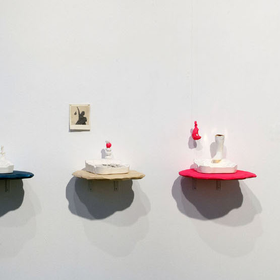 Sierra Slentz, Invasive and Unsustainable Ashtray Series, 2018. Wall installation: ceramic earthenware, glaze, luster, decal, wood, spraypaint. 16 x 62.5 x 8” Courtesy of the artist. Five different sculptures of ashtrays with different types of symbols placed around them. Sierra Slentz, Invasive and Unsustainable Ashtray Series, 2018. Wall installation: ceramic earthenware, glaze, luster, decal, wood, spraypaint. 16 x 62.5 x 8” Courtesy of the artist.