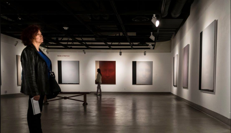 isitors engaged in Roni Stretch section of About Face exhibition. navigate down for further details