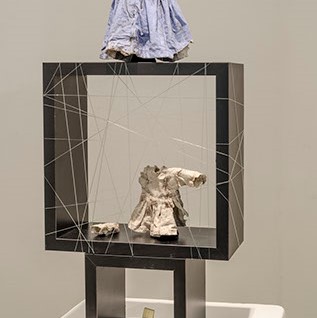 Ginny Barrett, "I’m Not Like That Anymore" a sculpture with a black square with string tied around it going in all directions.