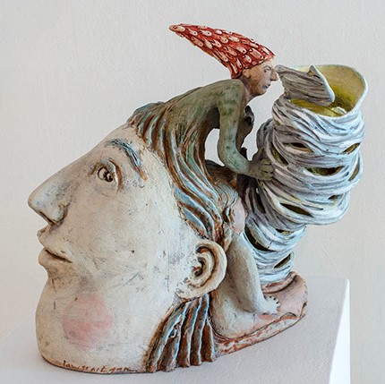 Gina Lawson-Egan, "Funnel Cloud" shows the head of a very pale figure. Where the hair is, there is another creature growing out of the head, wearing a pointy red hat.