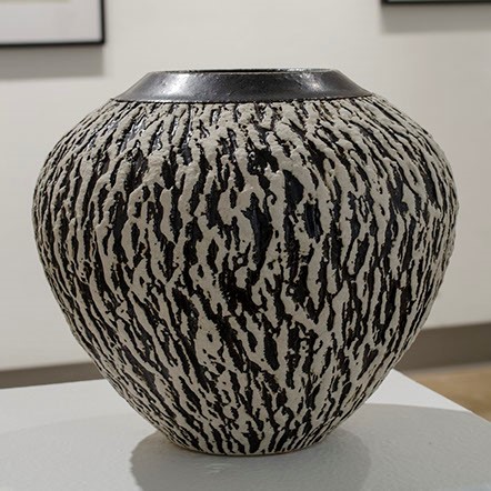 Lee Middleman, "Snowfall Globe" a large vase that gets slightly more narrow at the bottom. The vase is black and white.