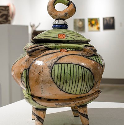 Daniel Oliver, "Pot Belly Box Series" is a brown and green sculpture. It looks like a miniature pot with a lid and has four legs.