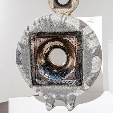 Heather Rosenman, "Magma Morph" an abstract circular grey sculpture with a hole in the middle.