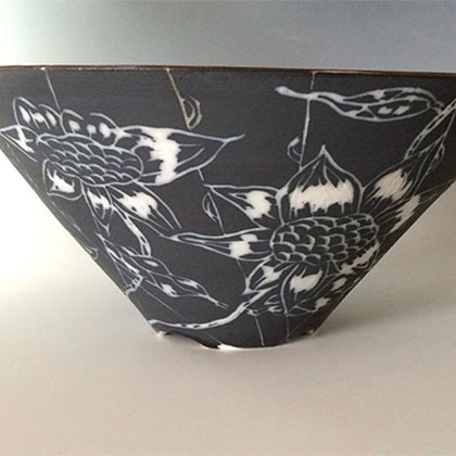 black porcelain bowl with white flower incisions around it