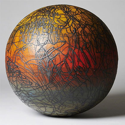 ombre orange and green sphere made from stoneware and underglazes with black scribbles all around it