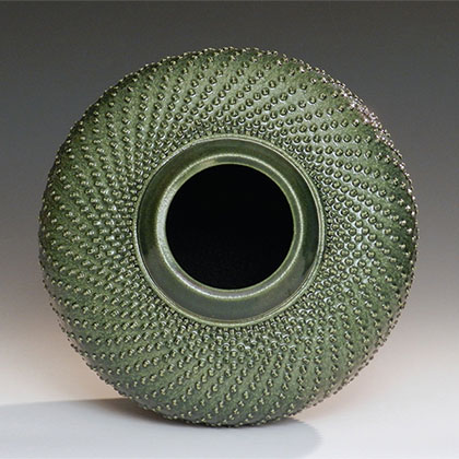 stoneware, wheel-thrown, hand textured, green bowl that resembles a new sprouting sunflower bud 