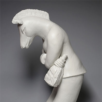 white ceramic sculpture of a horse standing like a human, slightly bowed, and holding a brown bag with an alcoholic beverage inside