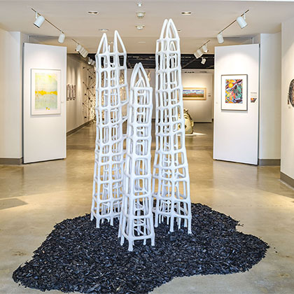 three white ceramic stoneware of tower-like cages inside cages on mulch