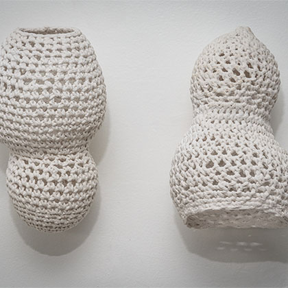 two pear-shaped white cotton yarn objects that were crochet to resemble polarizing body shapes