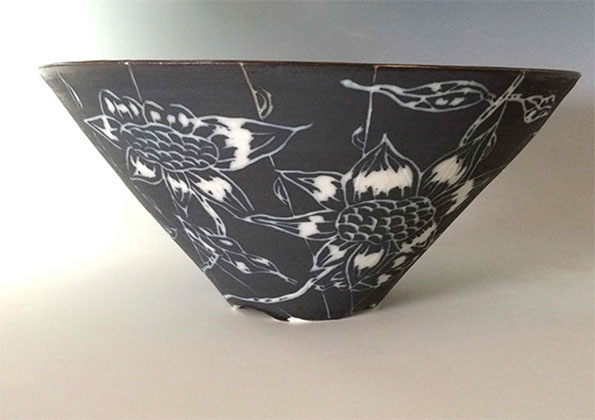 black porcelain bowl with white flower incisions around it