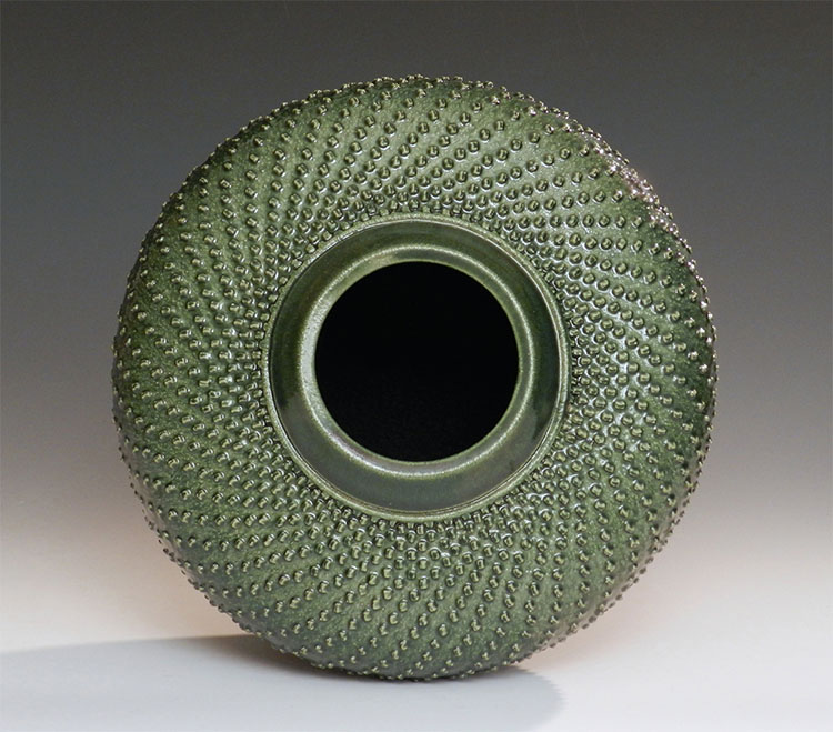 stoneware, wheel-thrown, hand textured, green bowl that resembles a new sprouting sunflower bud 