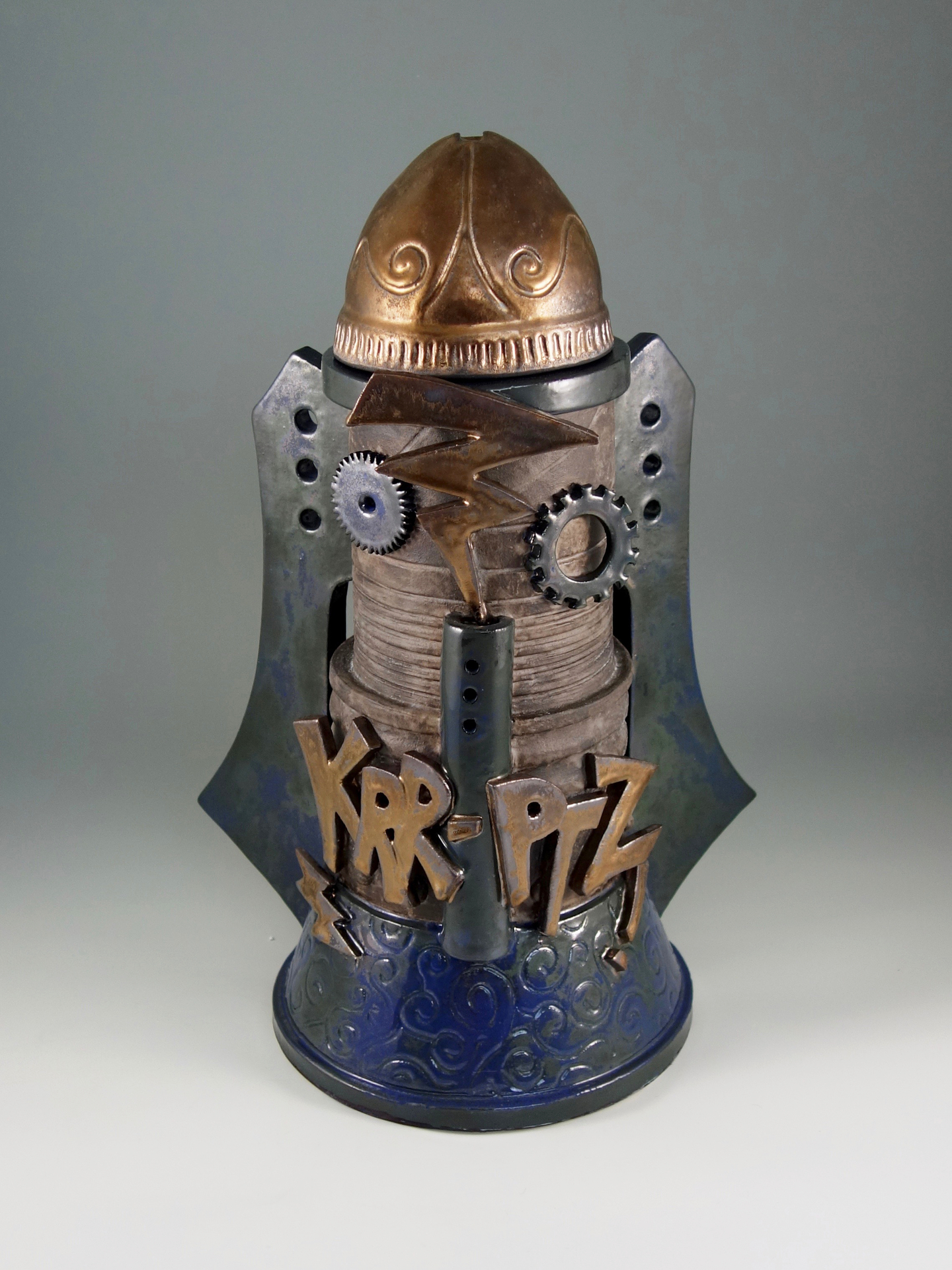  dark blue, metal, and bronze colored, futuristic style cookie jar with the word "KRR-PTZ" on the front with metal cogs and bronzed lightening strikes.