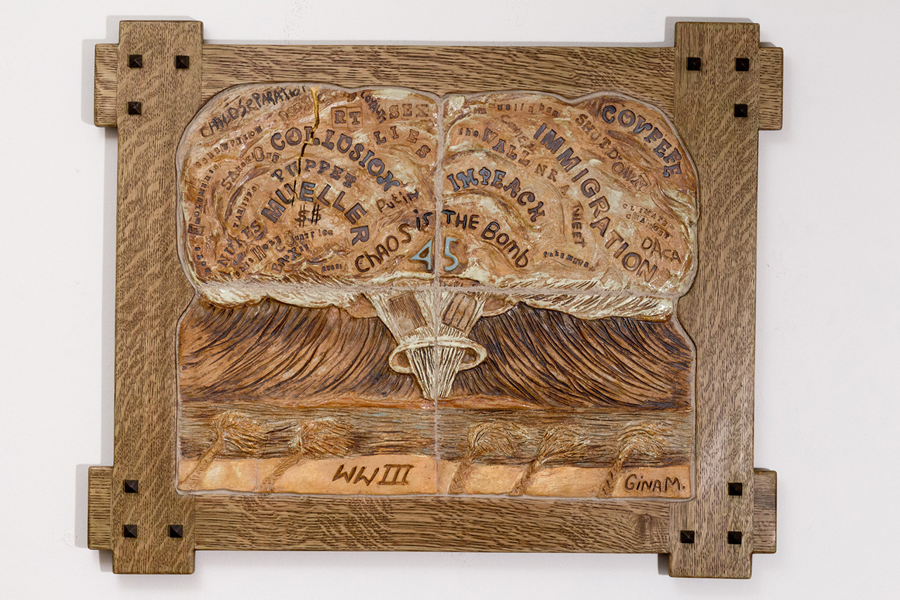  a wooden frame that showcases a mushroom cloud that contains different words with the numbers "45" in the middle of the cloud with the letters "WWII" beneath the mushroom cloud.