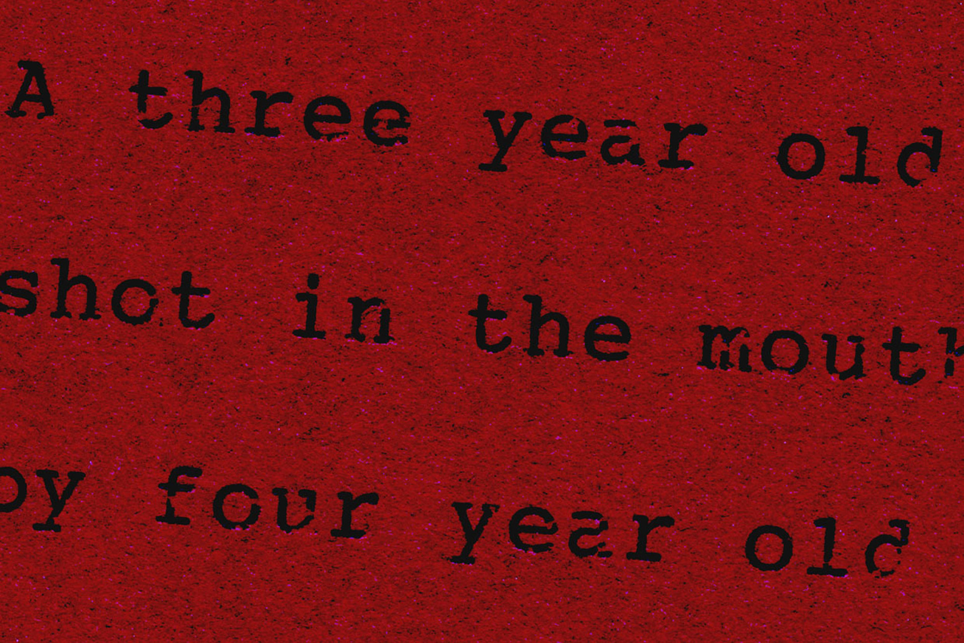 a red background with black printed words that say, "A three year old shot in the mouth by four year old" across the print.