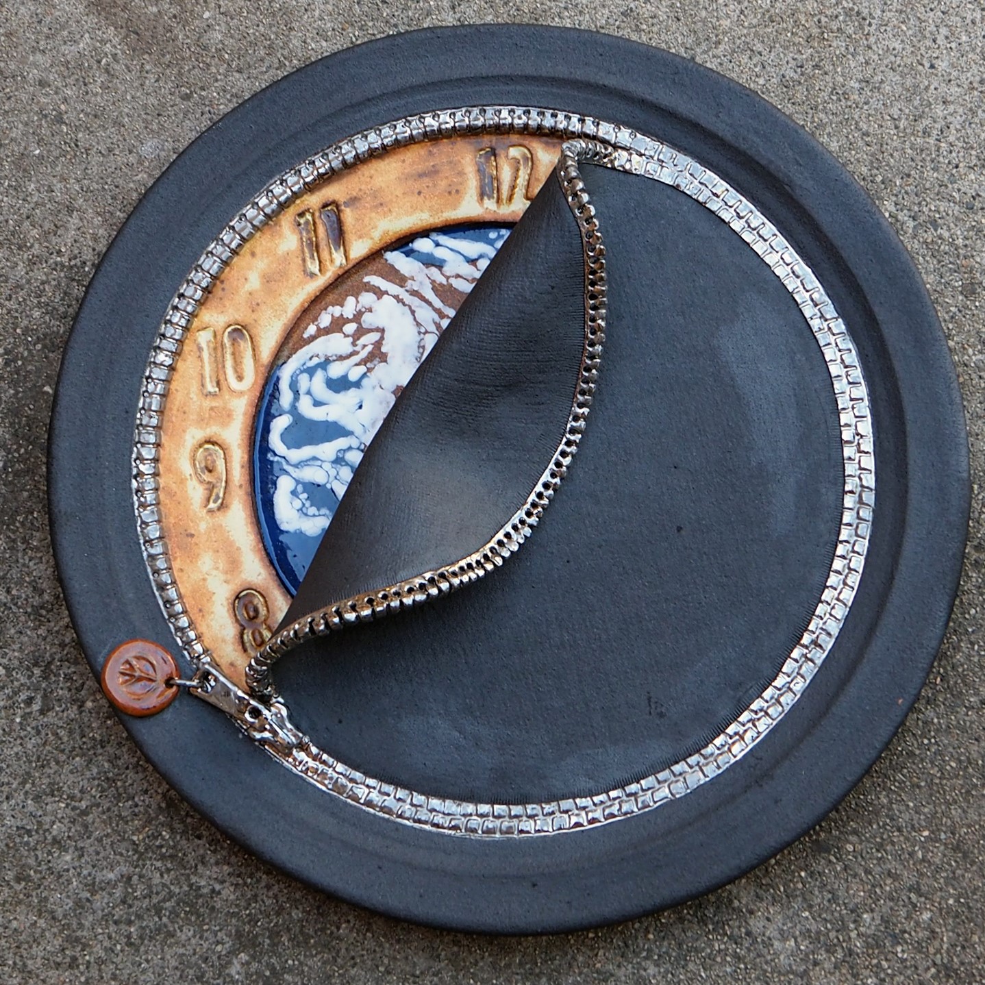 an open zipper reveals a clock with a picture of the world inside of the zipper.