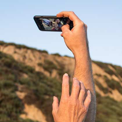 photography of hands reaching out to take a family selfie