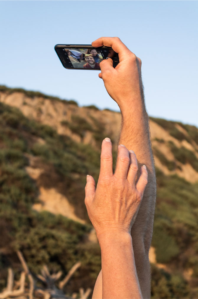 photography of hands reaching out to take a family selfie