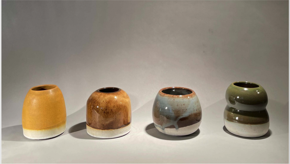 A photograph of four pottery pieces each with different colors right next to each other
