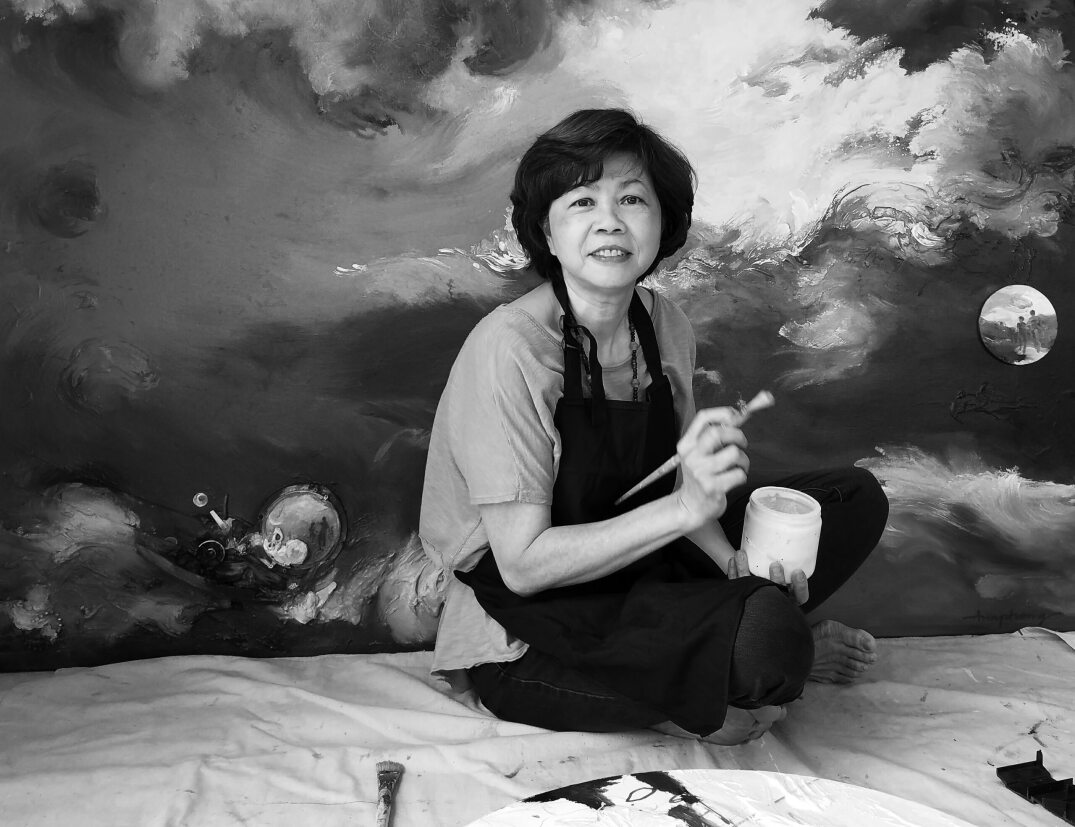 Black and white picture of Ann Phong holding a paintbrush