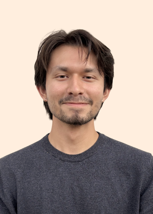 Headshot image of a young man with dark hair, light facial hair and pierced ears.