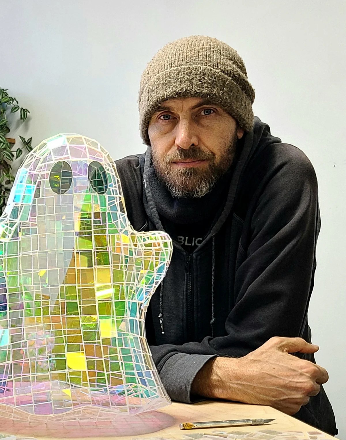 Colin Roberts posing with one of his glass mosaic artworks.