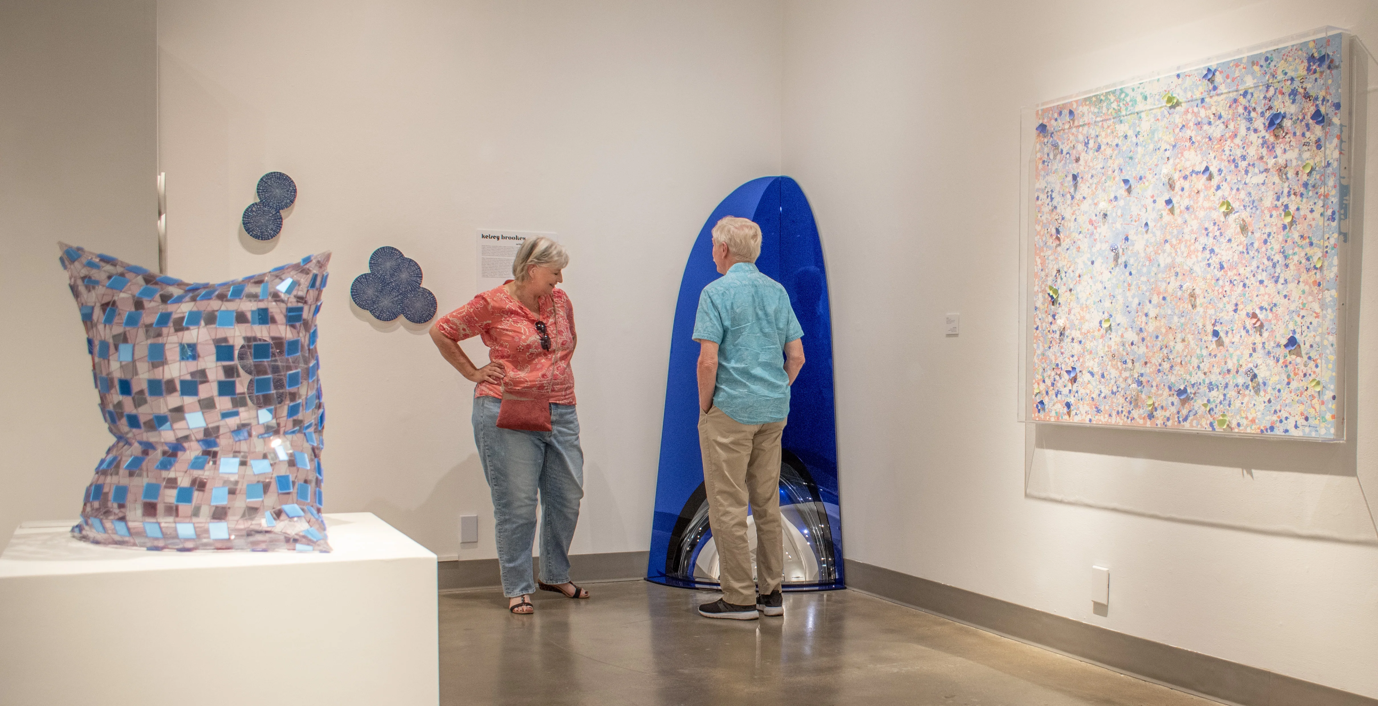 An elderly couple observes artwork within the west gallery.