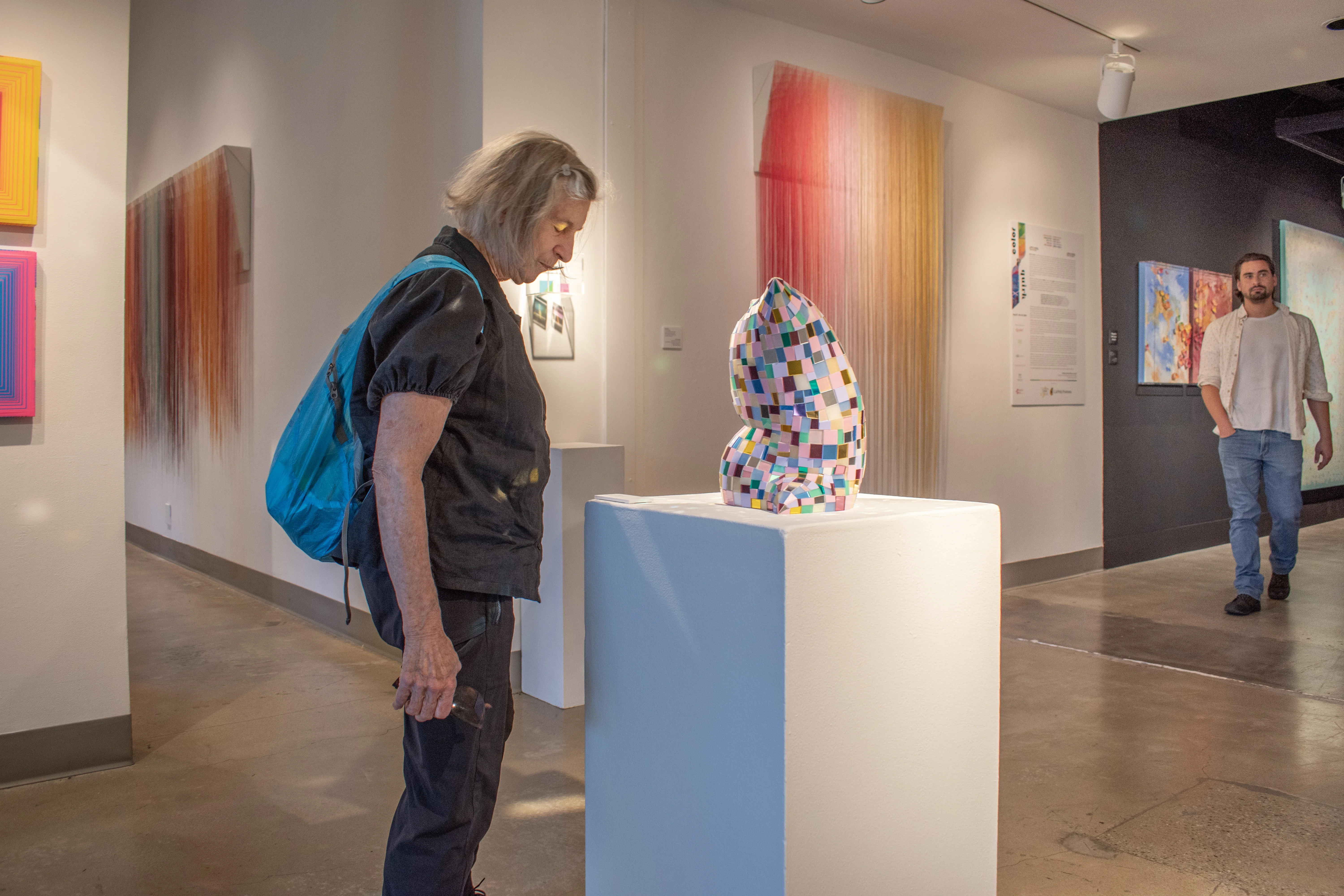 Visitor looking at one of Colin Roberts mirror pillows.