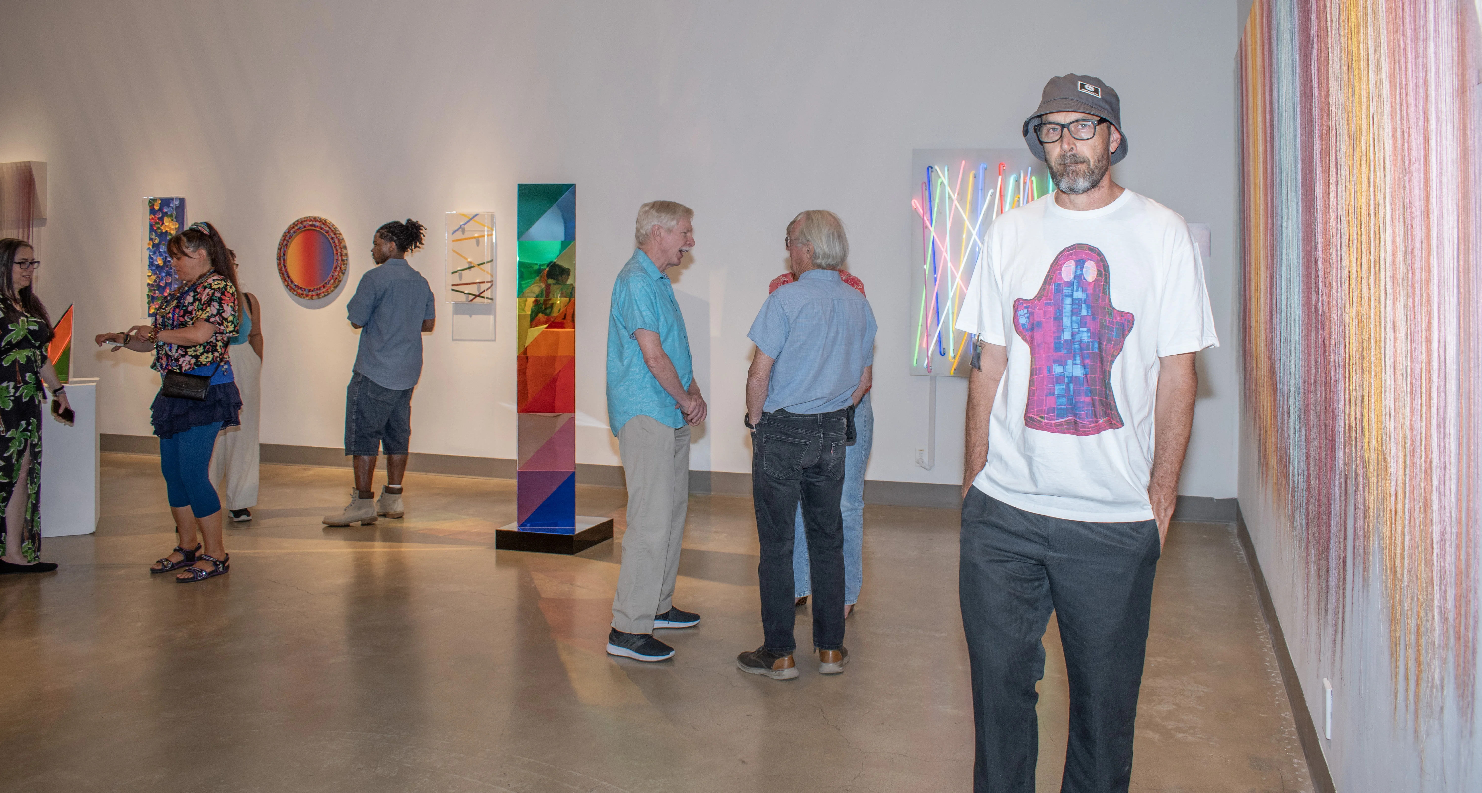 Colin Roberts stands amongst guests within the east gallery.