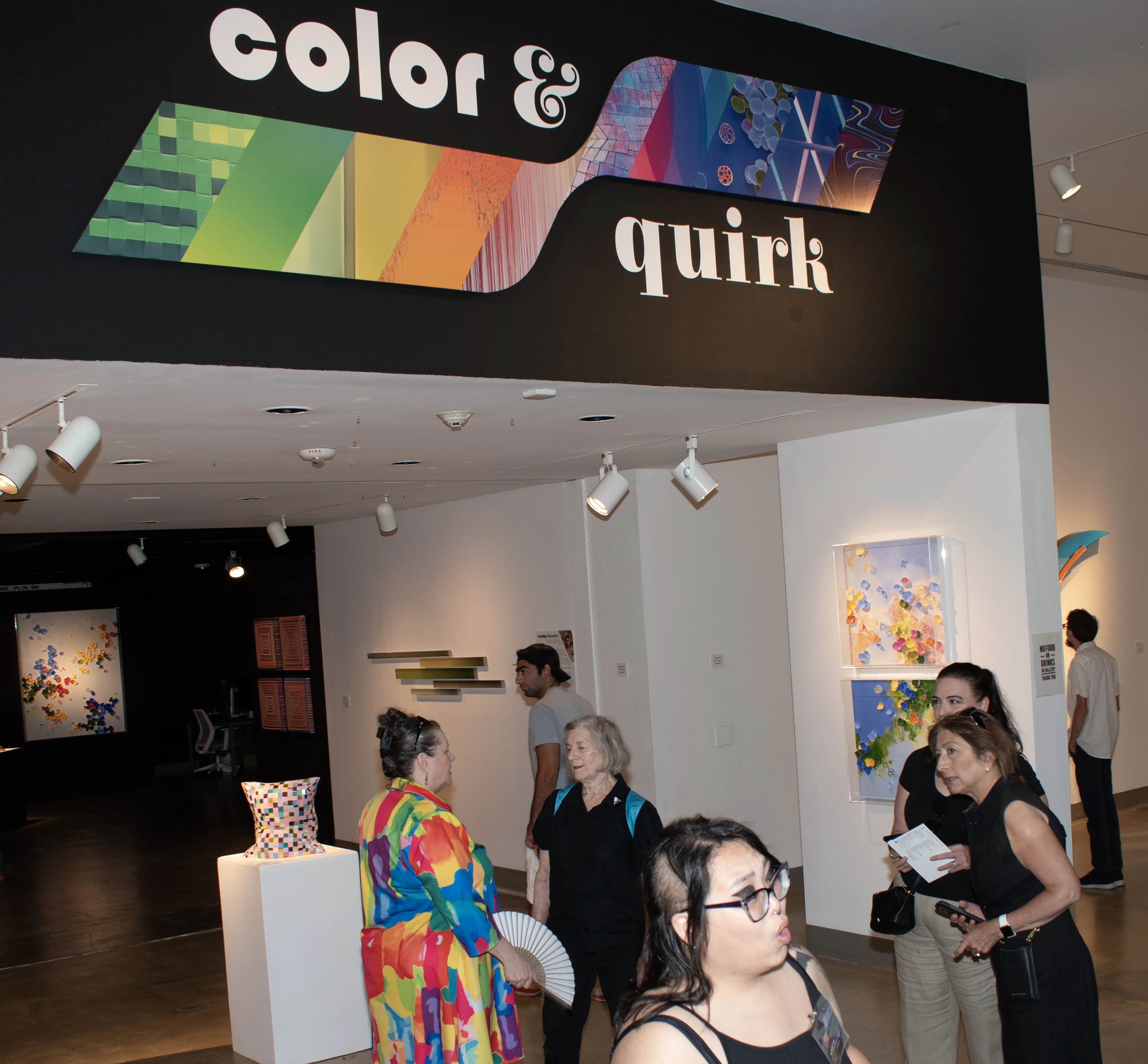 Guests interacting in front of the "Color & Quirk" title wall.