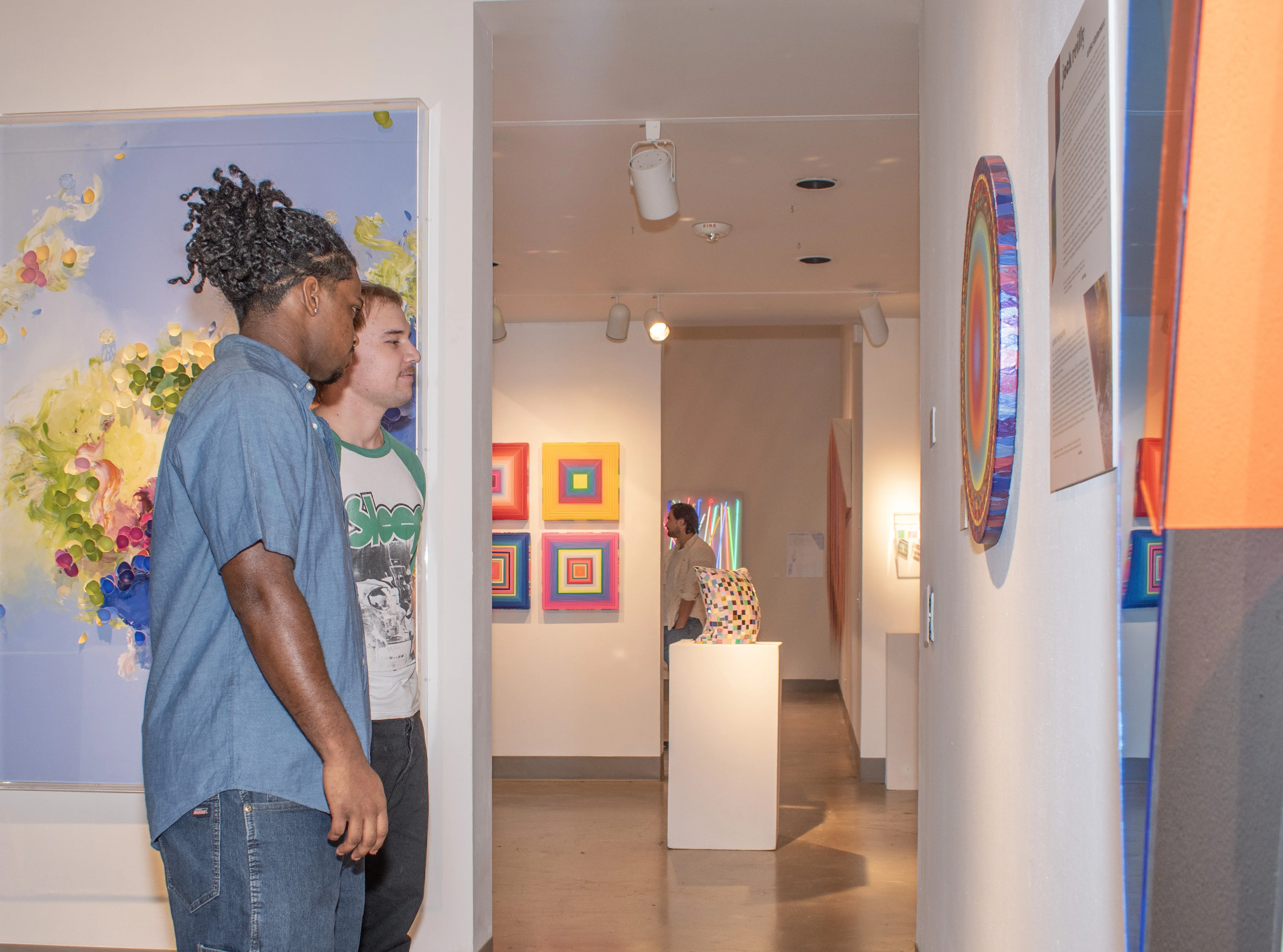 Guests observing artwork by Jack Reilly.