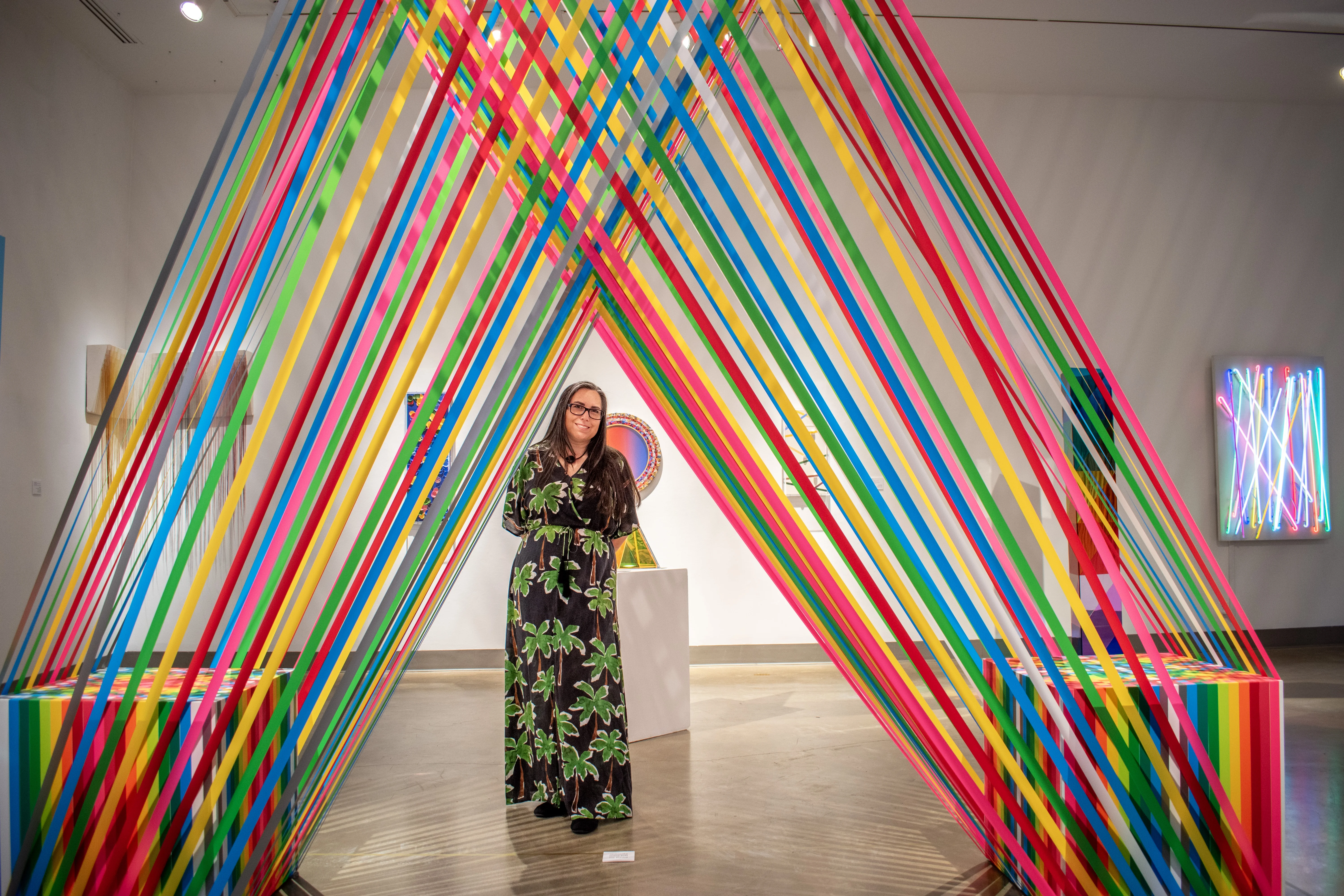 Artist Megan Geckler posing under one of her artworks.