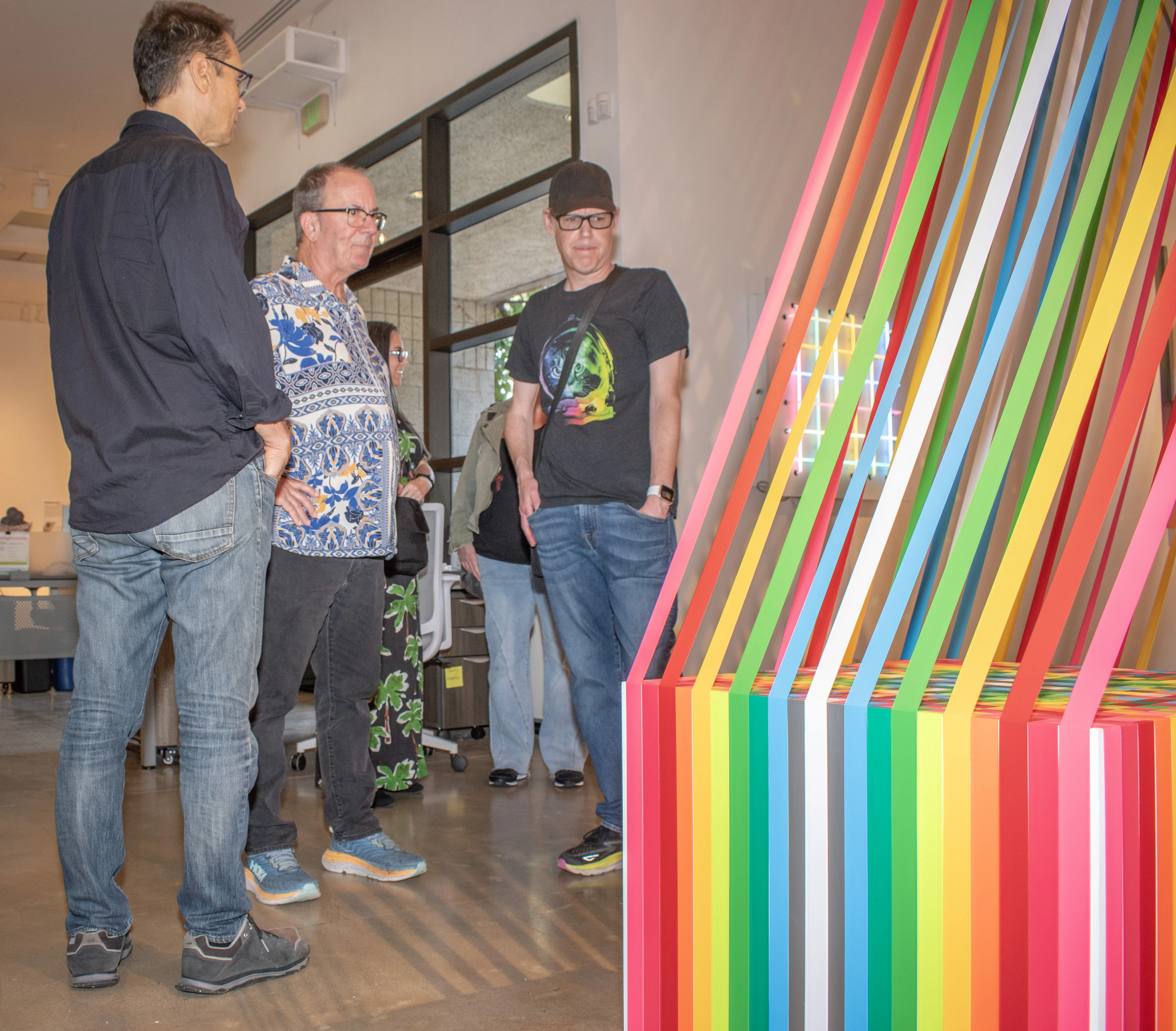 A group of visitors stand before one of Megan Geckler's artwork.