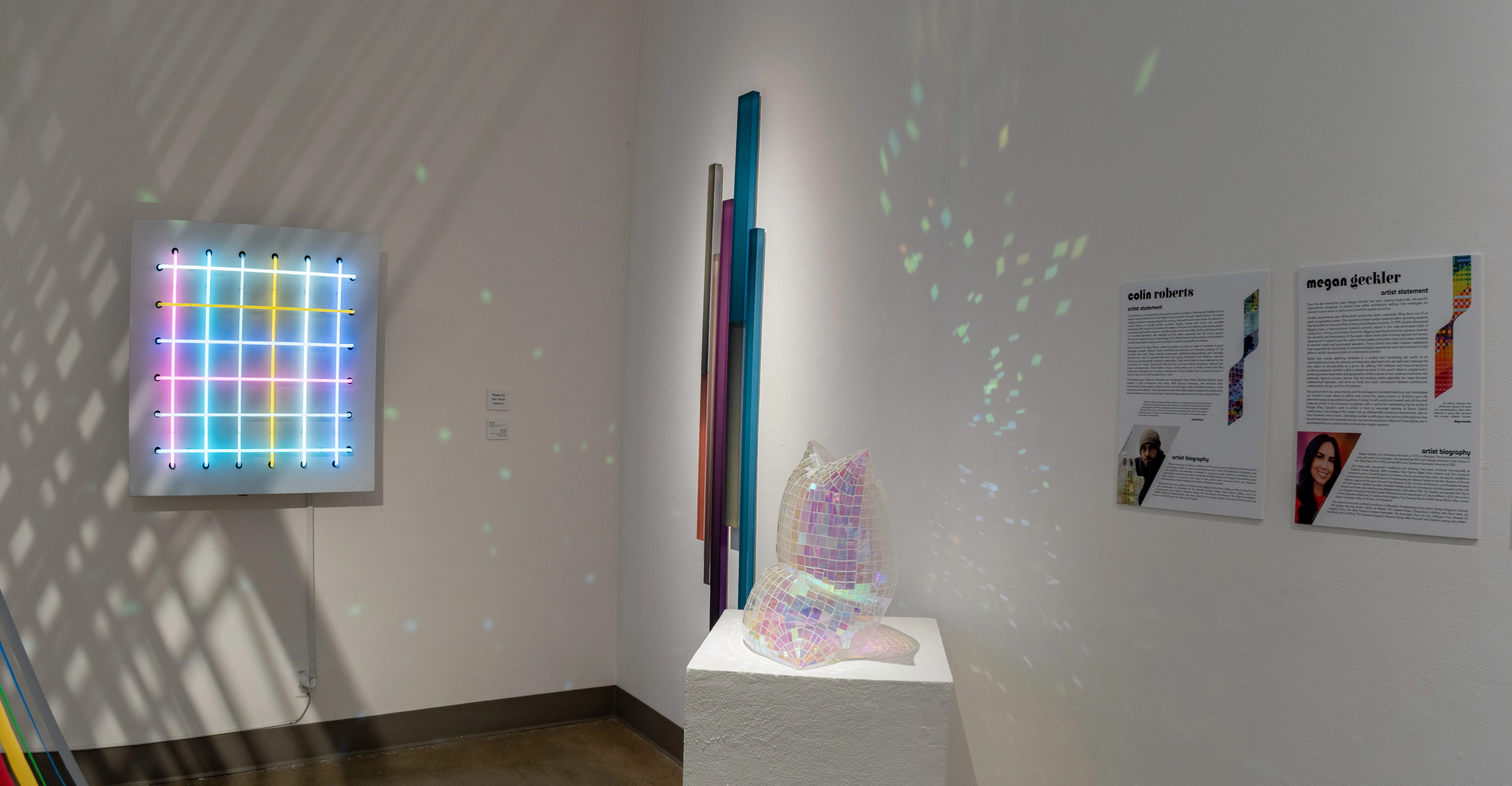 Corner shot of the East Gallery west wall featuring artwork by Phillip Vaughan, Freddy Chandra and Colin Roberts.