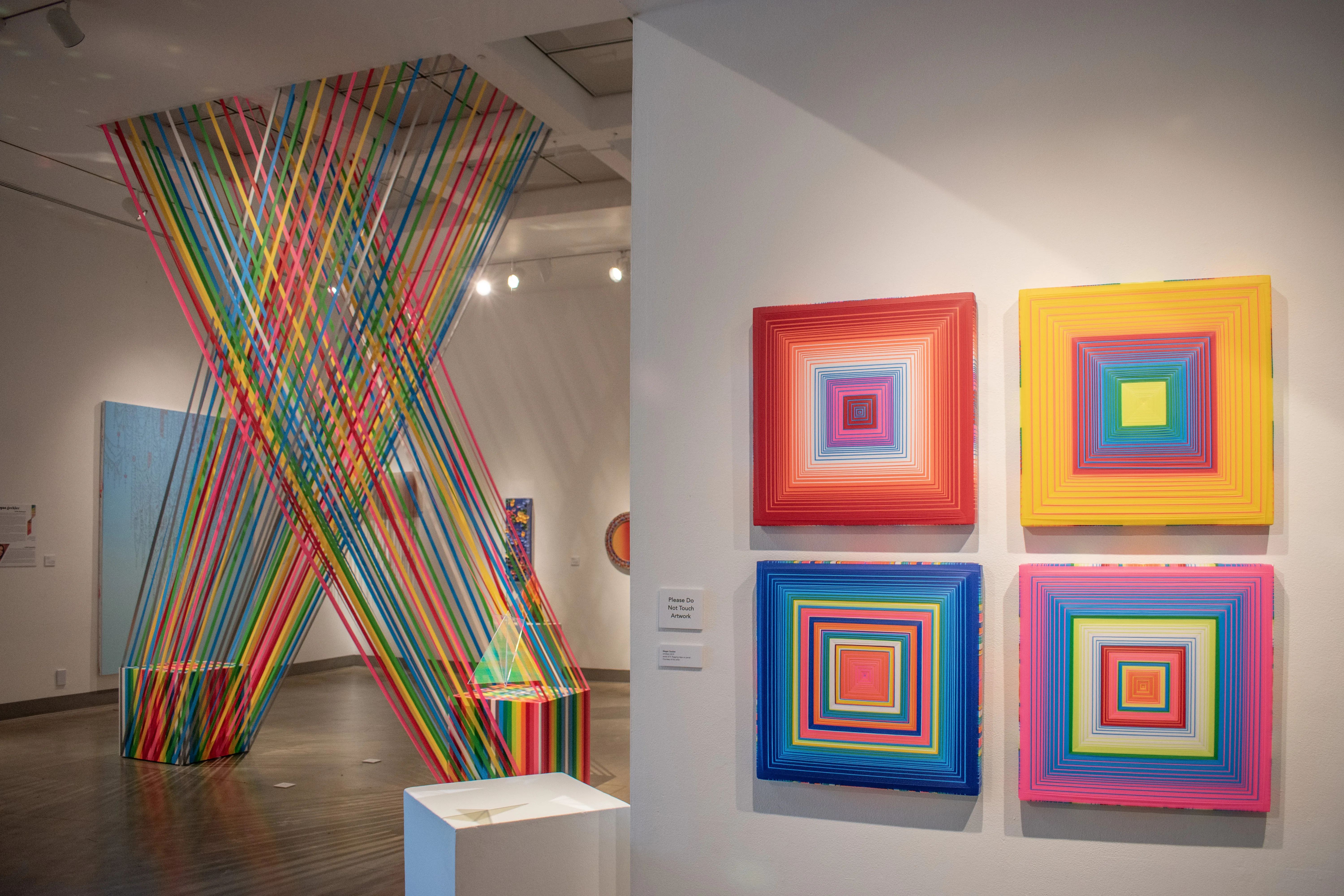 Installation view of gallery corridor peaking into East gallery.